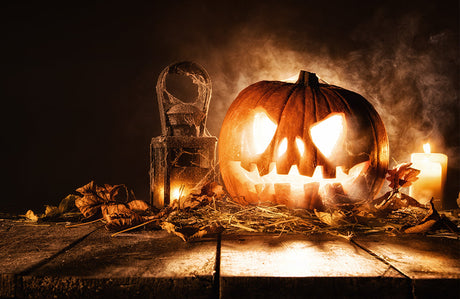 Gruseliger Halloweenkürbis auf Holzbrettern.