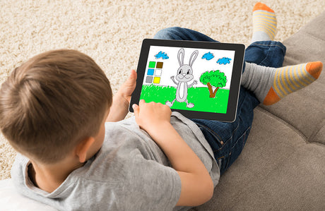 Ein kleines Kind spielt ein Spiel auf einem digitalem Tablet.